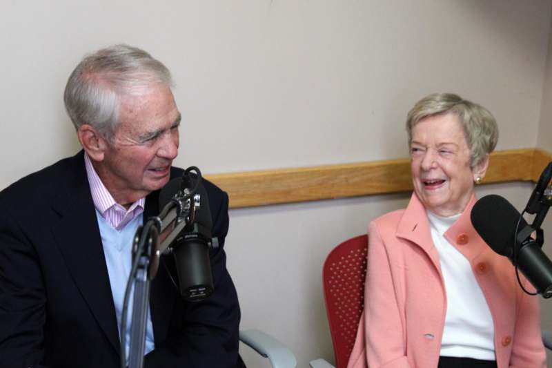 a man and woman talking into a microphone