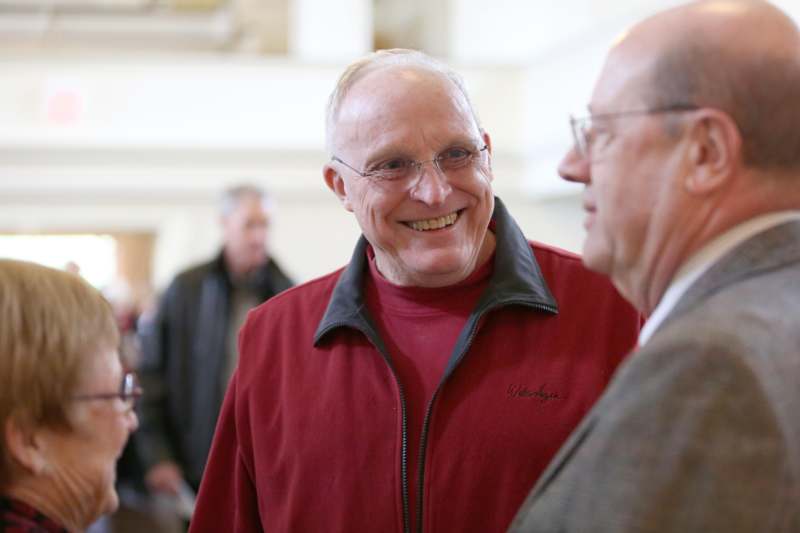 a man in a red sweater and glasses smiling