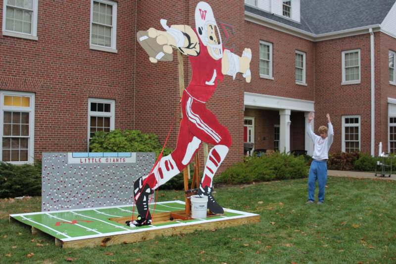 a man standing in front of a large cardboard cutout of a football player
