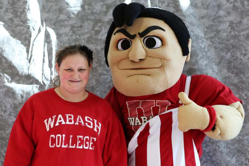 a woman standing next to a person wearing a mascot