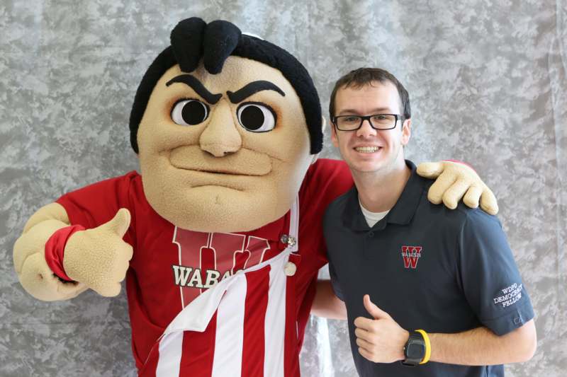 a man posing with a mascot