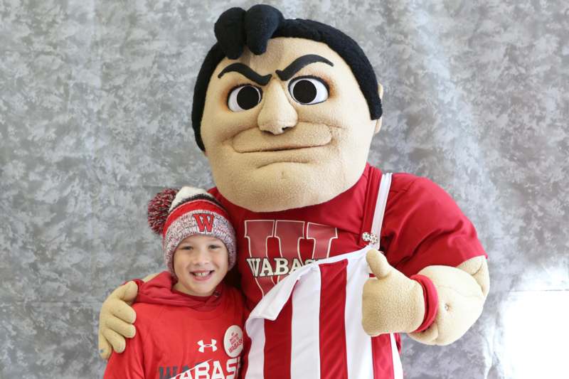 a boy posing with a mascot