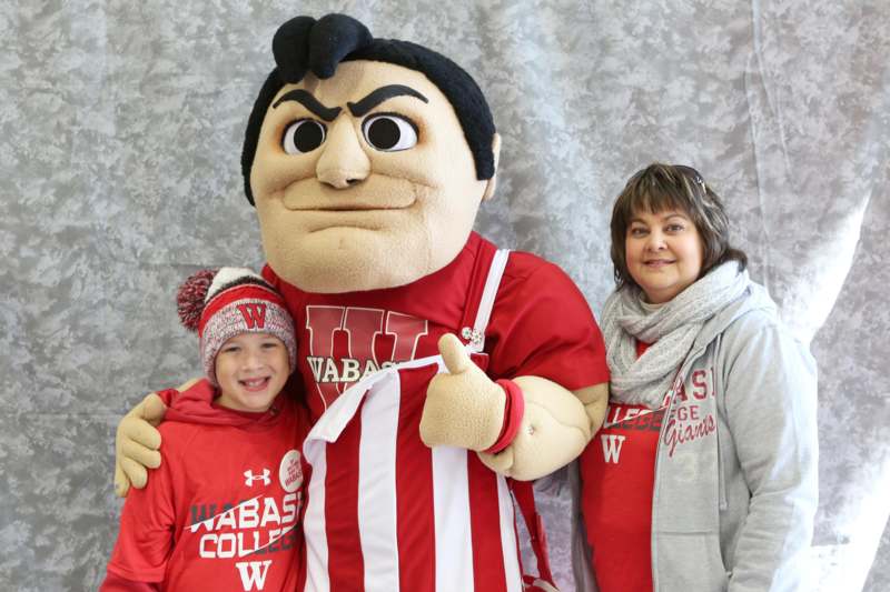 a woman and a boy posing with a mascot