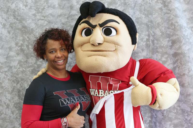 a woman posing with a mascot