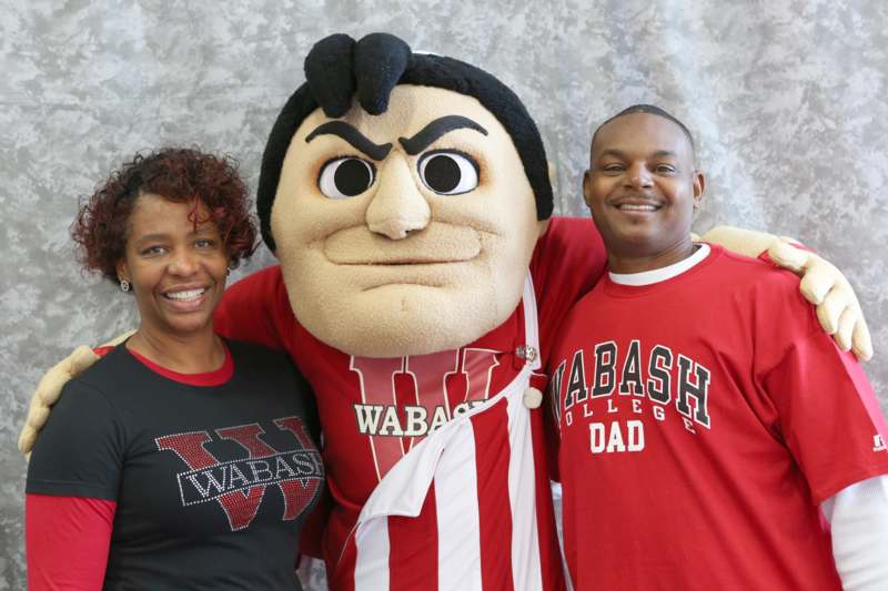 a man and woman posing with a mascot