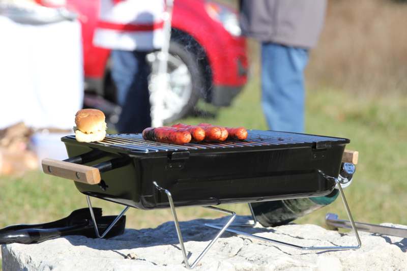 a grill with hot dogs and a bun on it