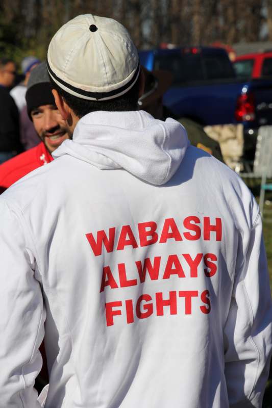 a man wearing a white jacket with red writing on it