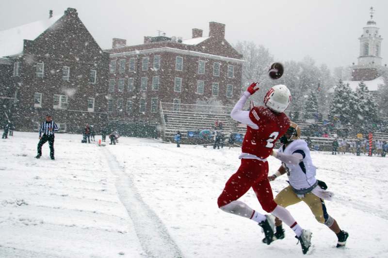 a football player catching a ball in the snow