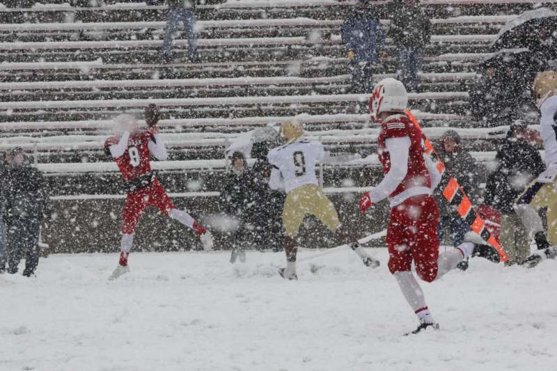 a group of people playing football in the snow