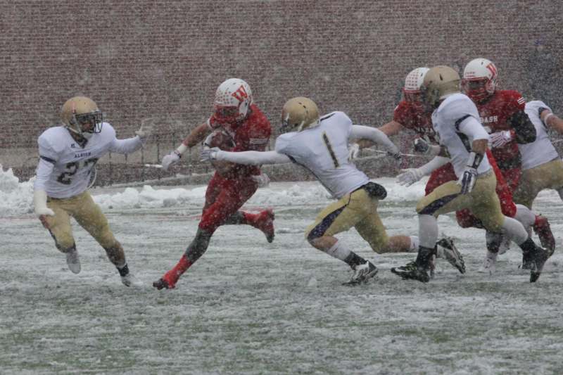 a group of football players running in the snow