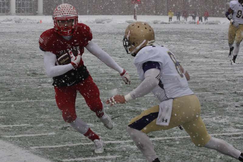 two football players running in the snow