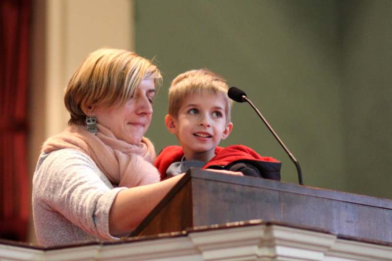 a woman and a boy standing at a podium
