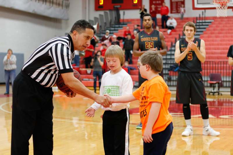 a man shaking hands with a basketball player