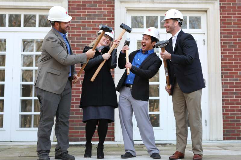 a group of people in hardhats holding hammers