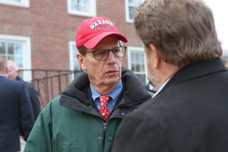 a man in a red hat talking to another man