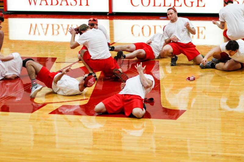 a group of people in red and white shirts on a wooden floor