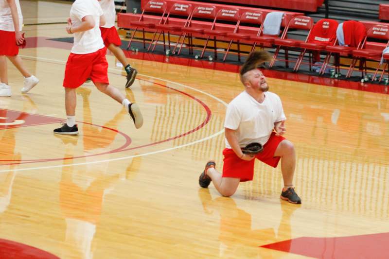 a man in red shorts and white shirts holding a frisbee