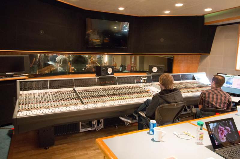 a man sitting in front of a large sound board
