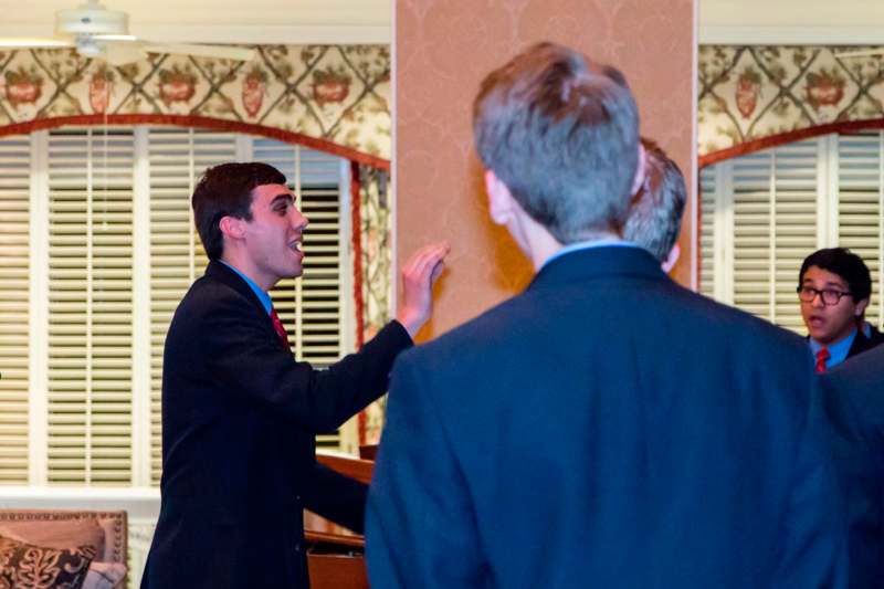 a man in a suit pointing to another man