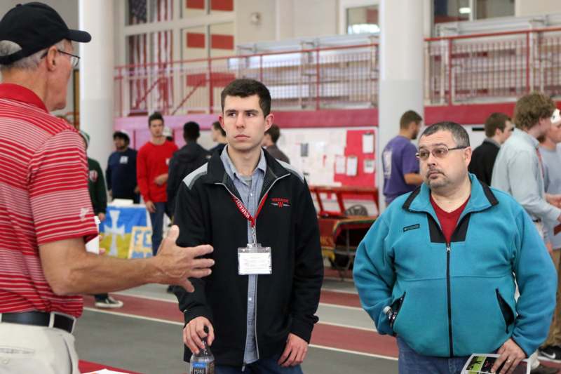 a man talking to a man in a sports hall