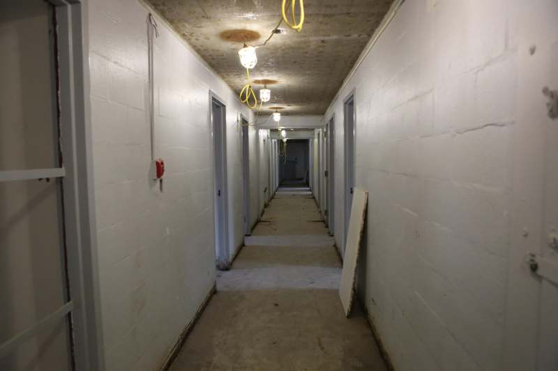 a long hallway with white walls and a light fixture