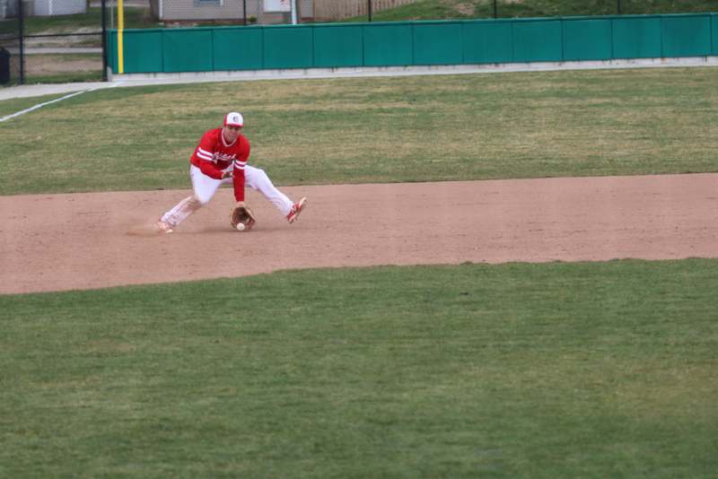 a baseball player in red and white uniform on a field