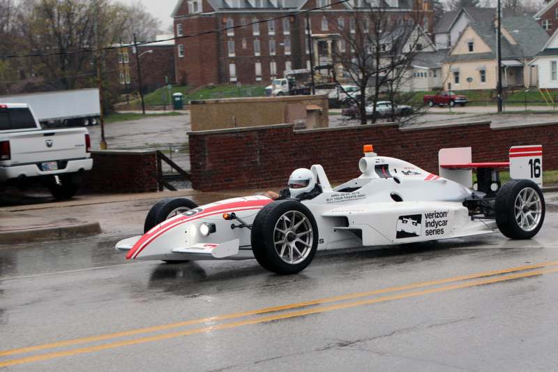 a white race car on a wet road