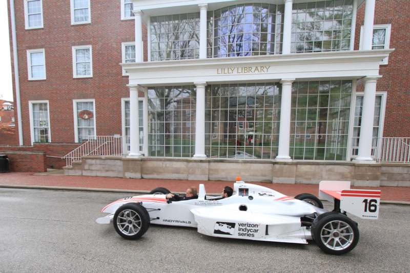 a white race car parked in front of a library