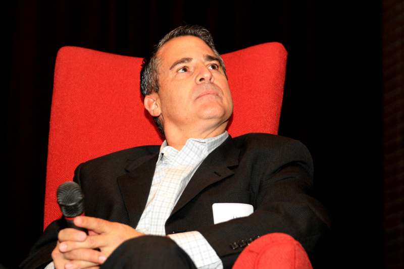 a man in a suit sitting in a red chair