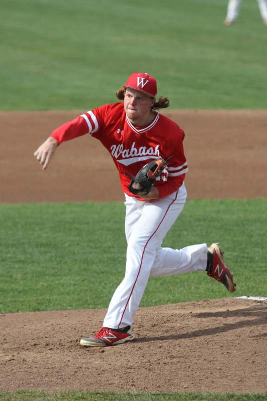 a baseball player in red and white uniform throwing a ball
