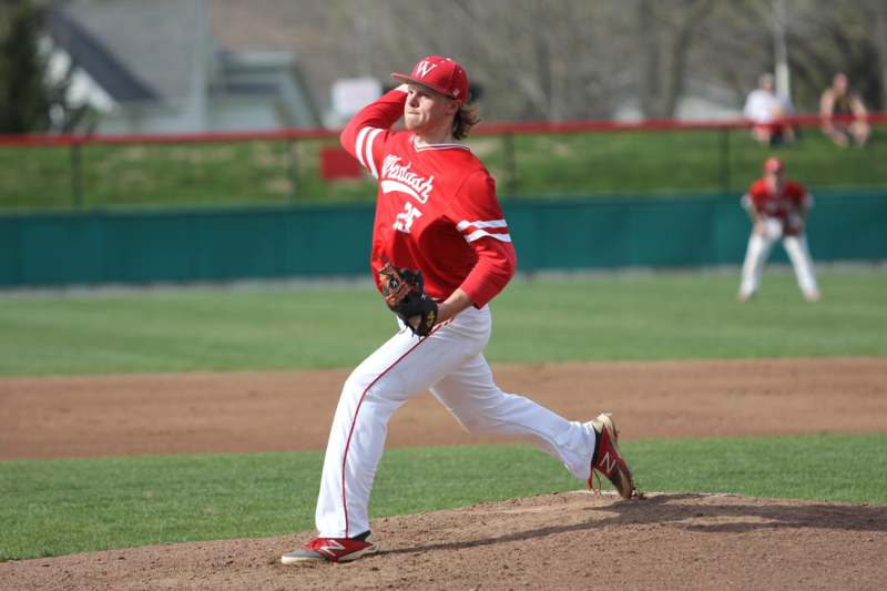 a baseball player in red uniform throwing a ball