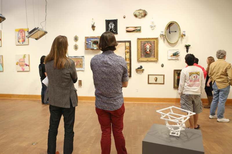 a group of people looking at art on a wall