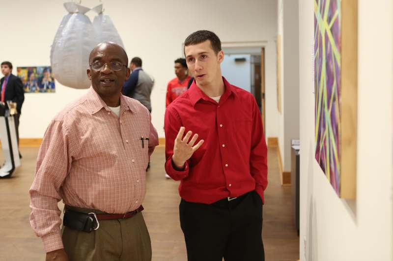 a man in a red shirt standing next to a man in a red shirt