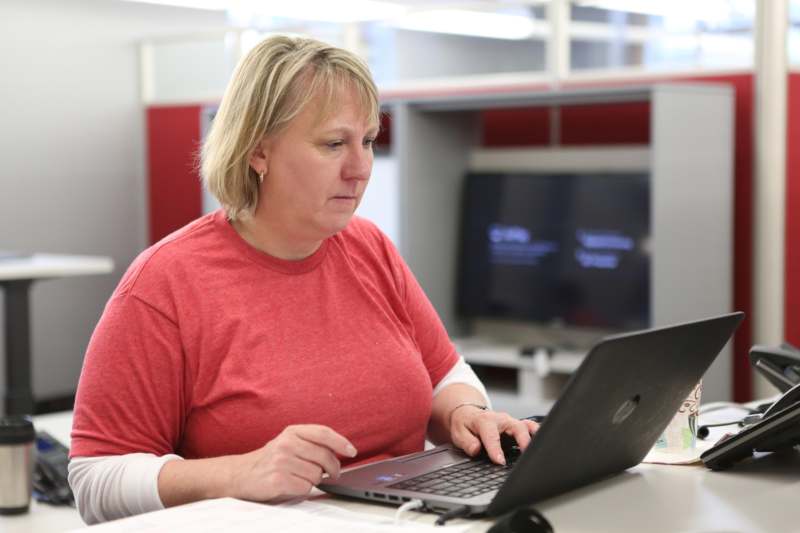 a woman sitting at a desk using a laptop