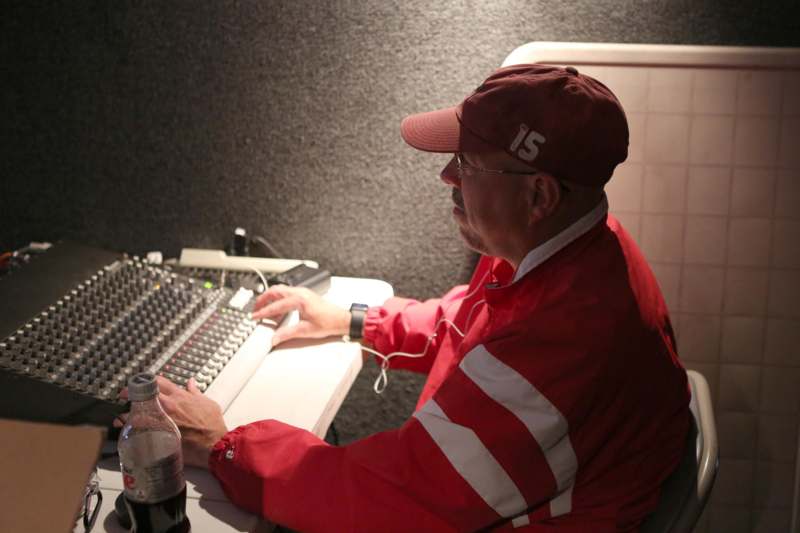 a man in red jacket and hat sitting at a desk with a keyboard