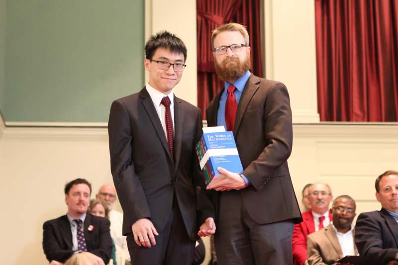 two men in suits holding books