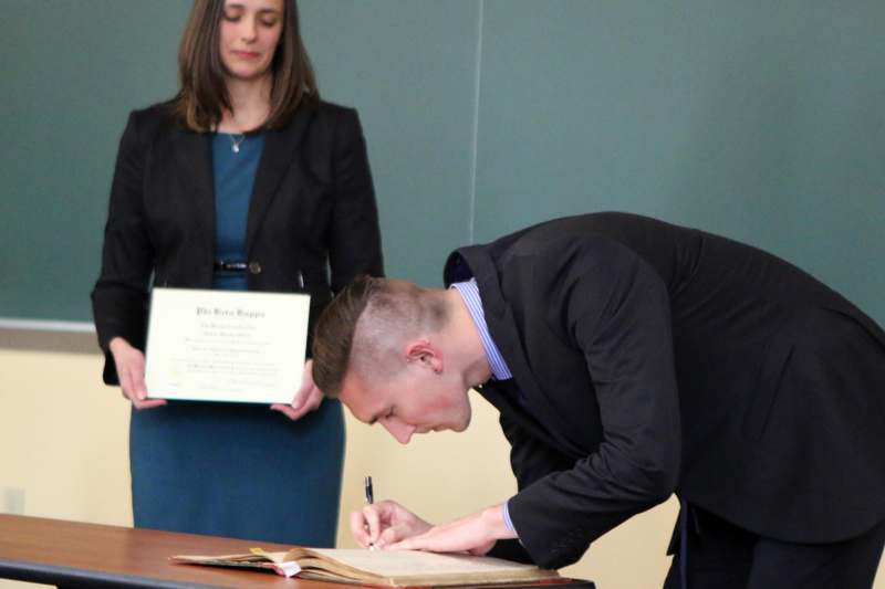 a man in a suit signing a document