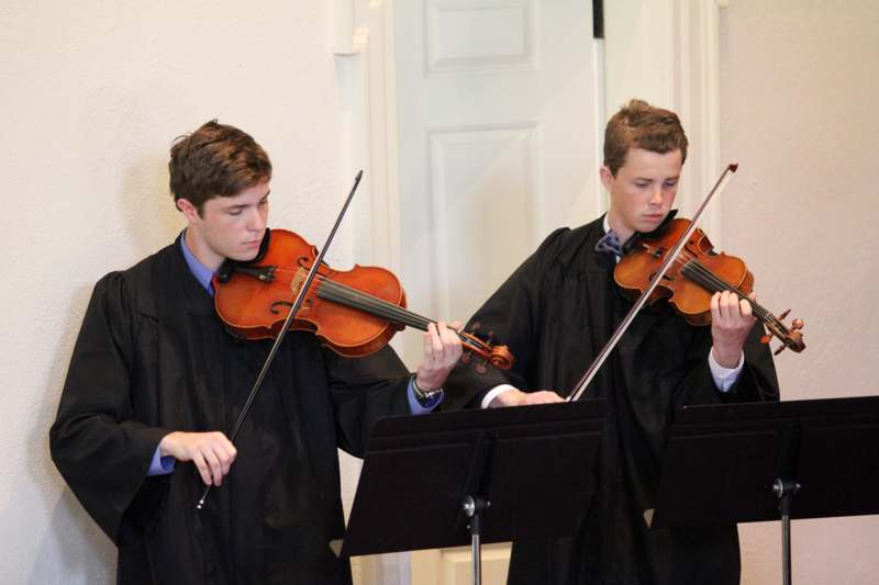 a group of men playing violins