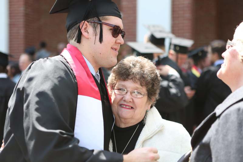 a man in a cap and gown hugging a woman