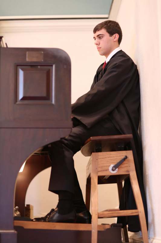 a man in a black suit playing a piano
