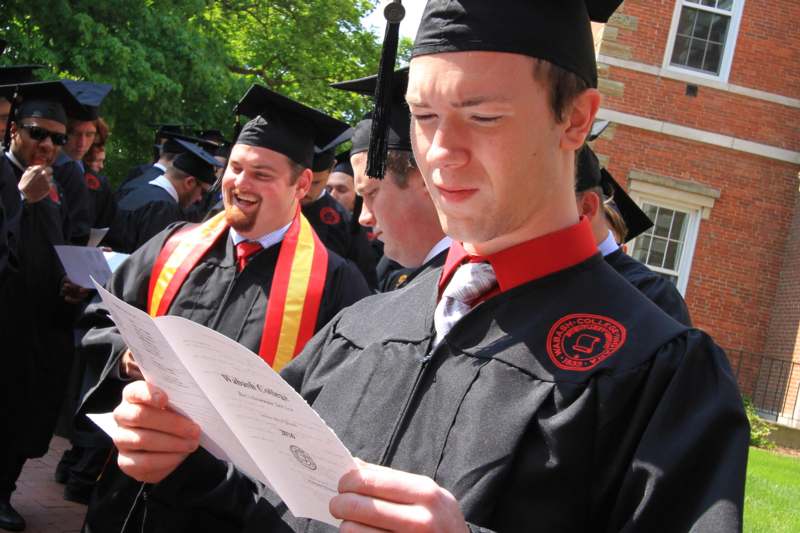 a group of graduates reading a paper