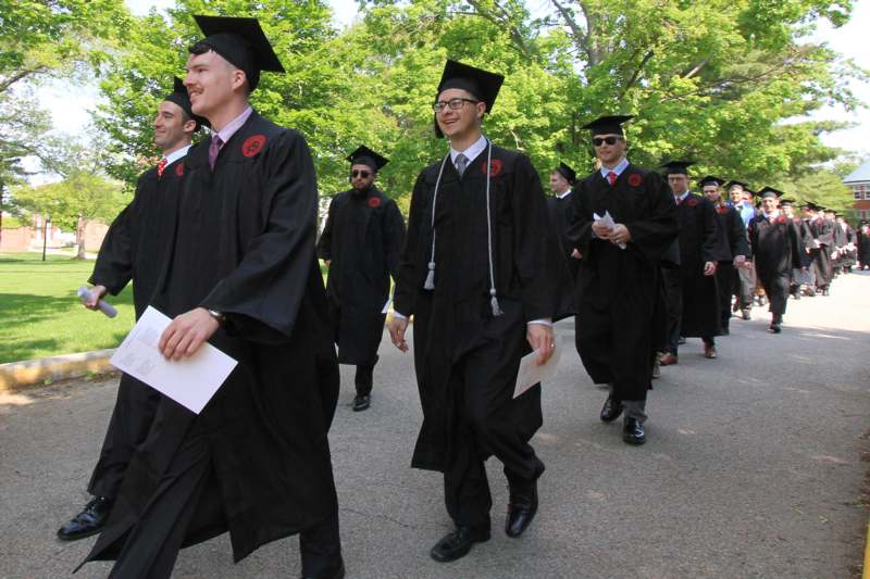 a group of men in graduation gowns walking