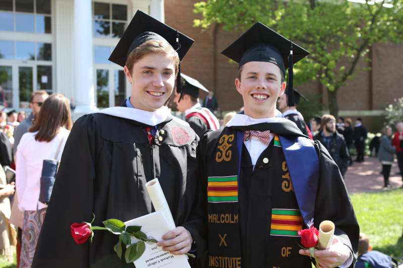 a couple of young men in graduation gowns and caps