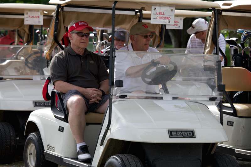 a group of men in a golf cart