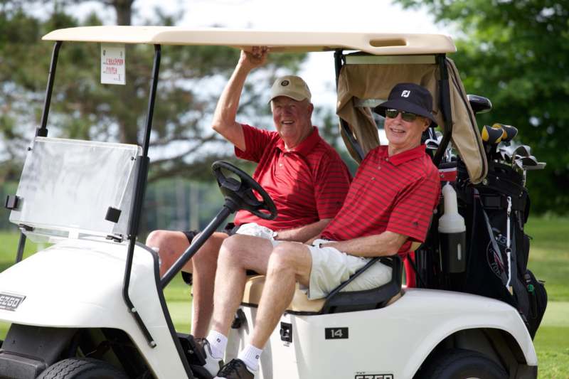 a pair of men in a golf cart
