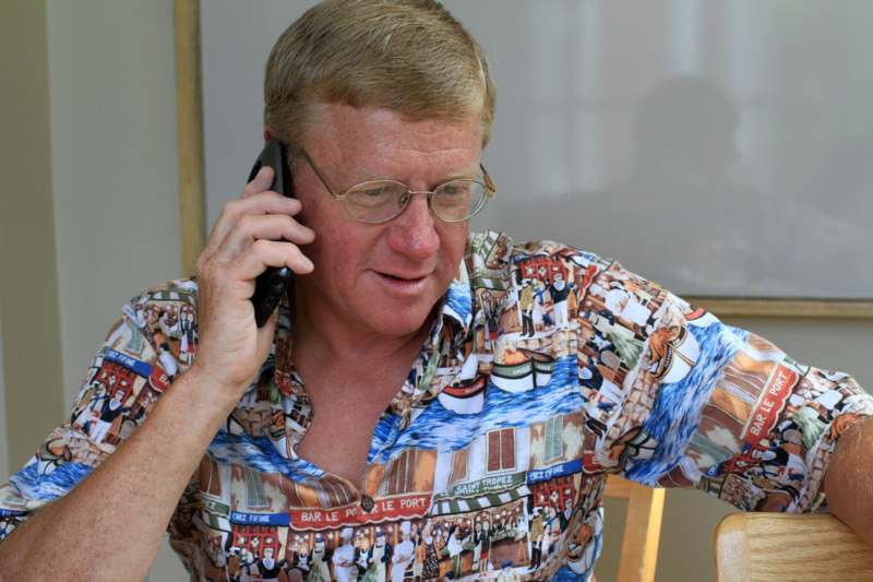 a man in a hawaiian shirt on a phone