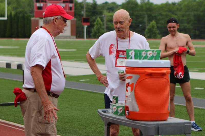 two men standing next to a cooler
