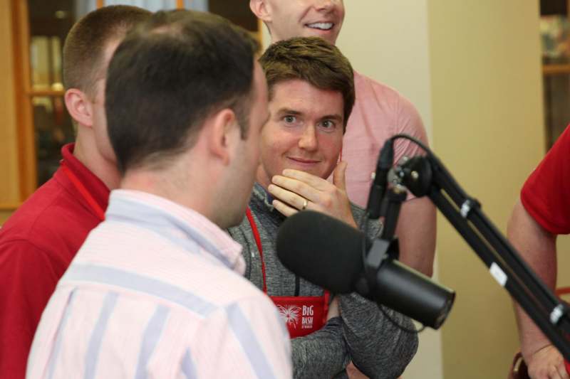 a group of men talking in front of a microphone