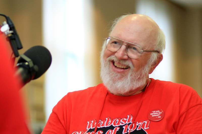 a man with a white beard and glasses smiling