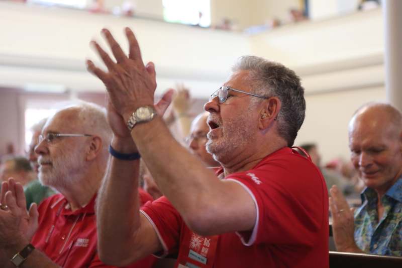 a group of men in red shirts clapping